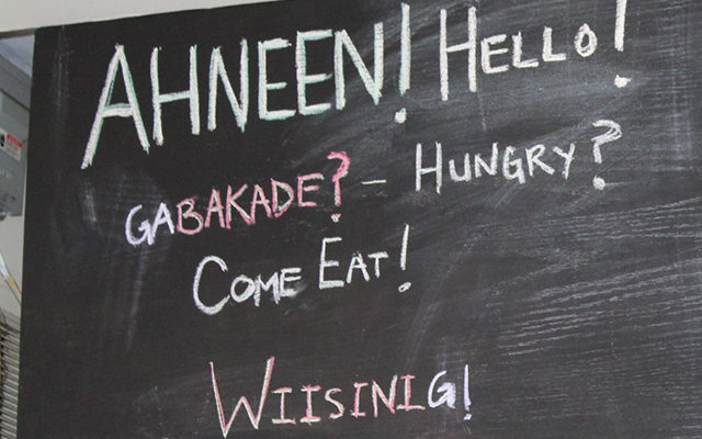 Chalk writing on a blackboard, which says 'AHNEEN! HELLO!', followed by 'GABAKADE? - HUNGRY? COME EAT!', then lastly, 'WIISINING!'.