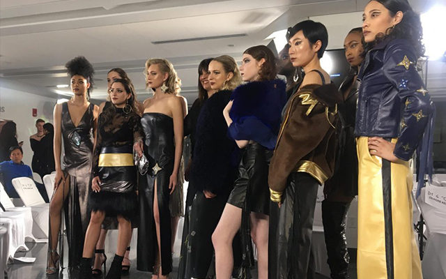 A group of people standing, who are dressed in fashionable clothes, looking at a central location.