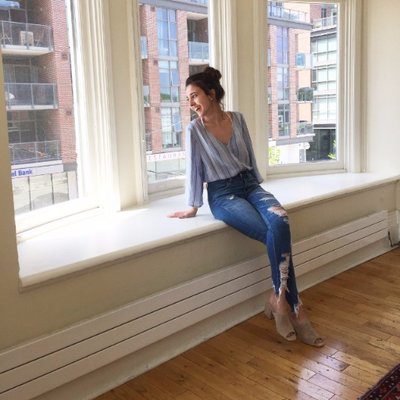 A photo of Jennifer La Grassa, sitting on a ledge, looking out a window.