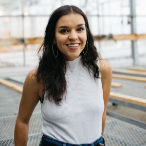 A photo of Katherine Singh, with an open indoor space blurred in the background.