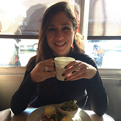 A photo of Stefanie Marotta holding a cup, sitting at a table.